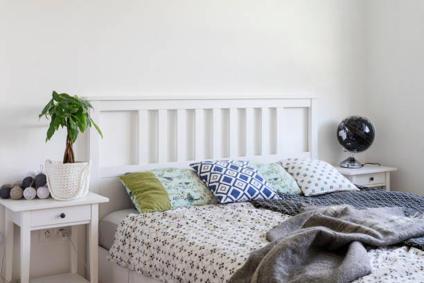 istock Comfortable bed in bedroom with pillow and blanket and white wall. 2119415316