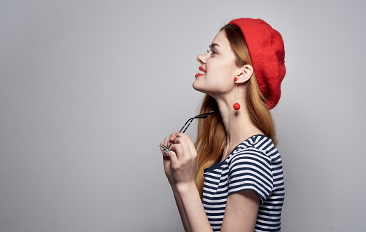 woman in red hat and striped t-shirt glasses on face portrait. High quality photo