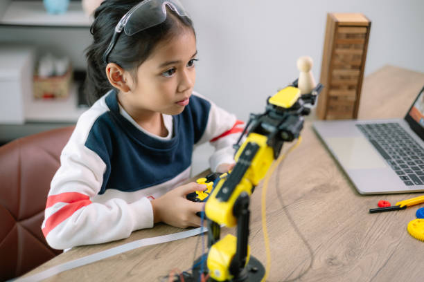 istock Asian girls were learning robot programming and getting lessons control on robot arms. Laboratory. Mathematics, engineering, science, technology, computer code, coding. STEM education. 2119505095