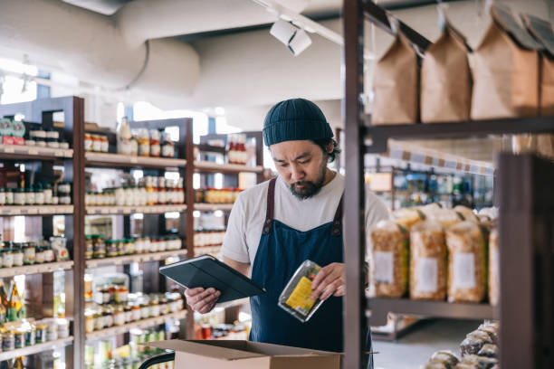istock Japanese convenience store employee fulfills a customer's online order using a digital tablet 2119518501
