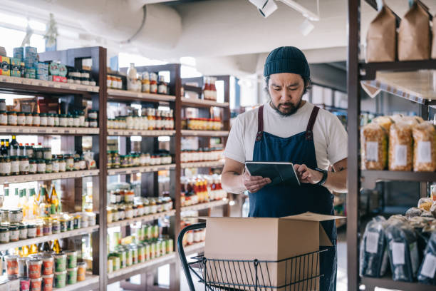istock Japanese convenience store employee fulfills a customer's online order using a digital tablet 2119518985