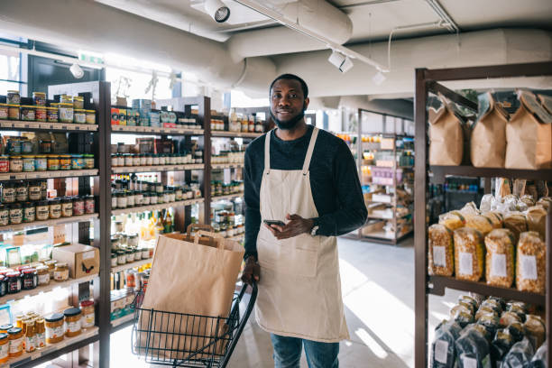 istock African store worker smiles warmly at the camera while filling a customer's online order 2119519043