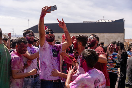 Uzbekistan, Samarkand, March 25, 2024: A group of people are taking pictures of themselves at a festival. Scene is lively and fun, as everyone is enjoying themselves and taking photos, Holi.