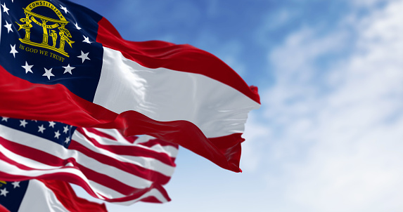 Flags of Georgia and United States waving in the wind on a clear day. Georgia is a state in the southeastern US. US federate state. 3d illustration render. Fluttering textile