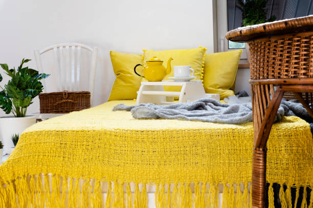 istock Comfortable bed in bedroom with yellow pillow and blanket and boho decoration. 2119545740