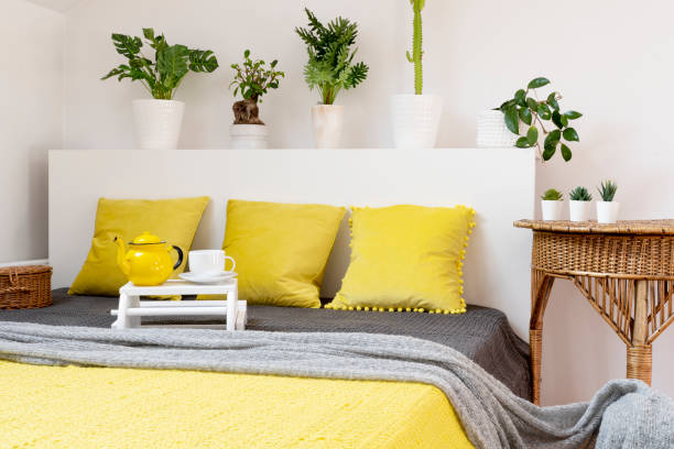 istock Comfortable bed in bedroom with yellow pillow and blanket and boho decoration. 2119546256