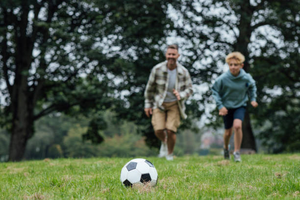 istock Father and Son Playing Football 2119547792