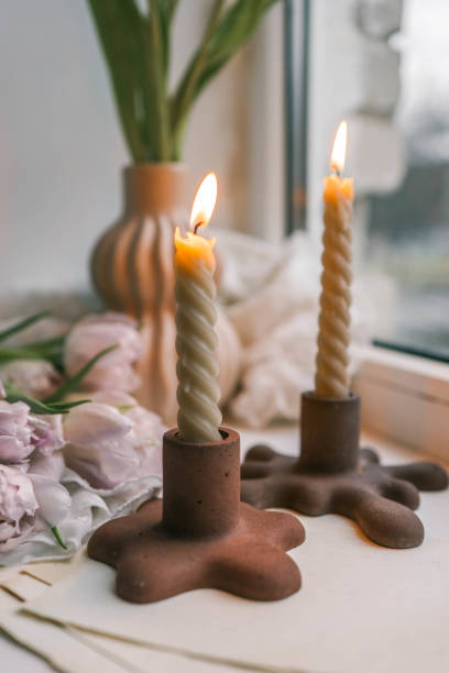 istock Spring aesthetics burning candles on candlesticks and pink tulips 2119556671