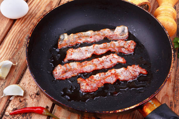 istock Fried bacon in a frying pan 2119582473