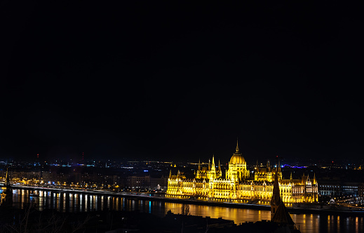 The Hungarian parliament building across the Daube from the Fishermans bastion ( Halaszbastya ) in the castle complex at Buda at night.