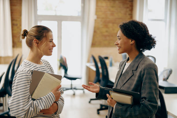istock Smiling diverse female employees is talking during break time in stylish office 2119595023