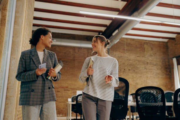 istock Smiling young diverse female employees talk during break time in stylish office 2119595026