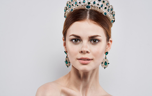 Romantic woman with a tiara and in earrings naked shoulders portrait model. High quality photo