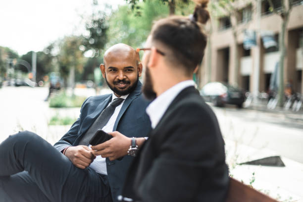 istock business men sharing idea on the bench 2119629738