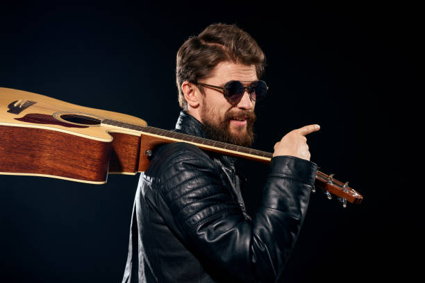 istock A man with a guitar in his hands leather jacket music performance rock star modern style dark background 2119636021