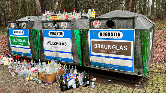 Itterbeck, Germany - Jan 3 2023 Too much waste! The glass containers are overflowing after the New Year's celebration