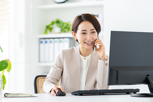 Middle-aged Japanese woman calling in the office