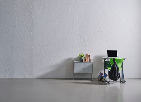 Grey stone wall background, school desk, opening of schools and starting school concept.