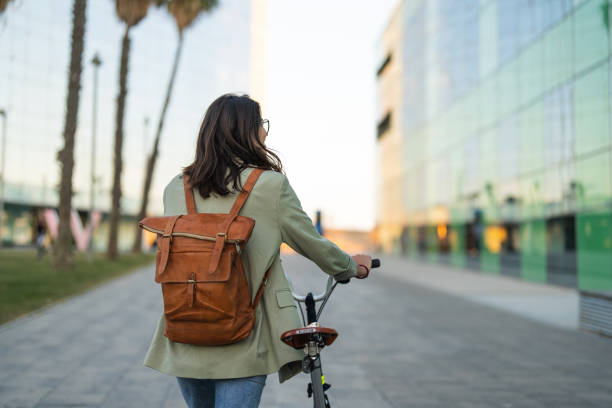 Young woman walking alongside with bicycle
