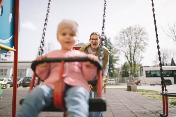 istock Mother and daughter on the swing 2119723011