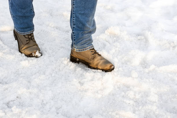 istock a man in boots walks through melted snow. 2119744696