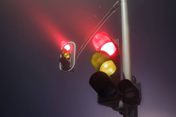 istock Traffic lights with red light during a foggy night. 2119786709