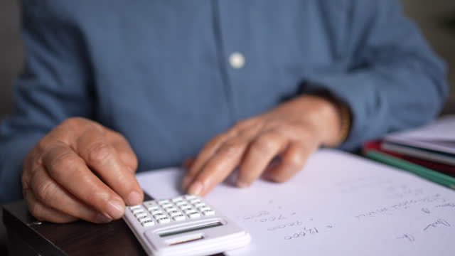 slow motion scene senior woman hand using calculator to calculate to planning money spending about pension lifestyle at home for money management after retired concept