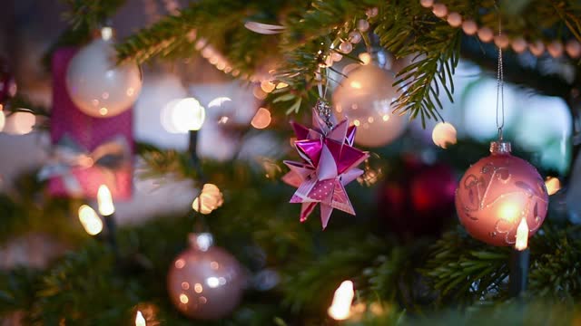 Closeup of a paper made Froebel Star with baubles in a Christmas tree against blur background