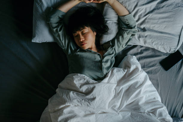 istock Asian woman sleeping in her bed 2119813609