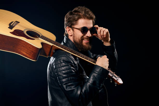 istock A man with a guitar in his hands leather jacket music performance rock star modern style dark background 2119814125