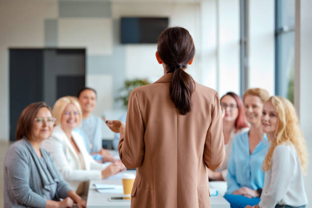 istock Rear view of female speaker explaining strategy while discussing with colleagues during conference meeting in office 2119844386