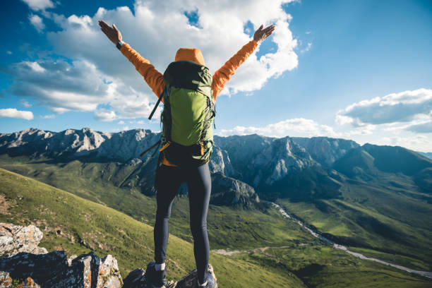 istock Successful woman backpacker hiking on alpine mountain peak 2119850699