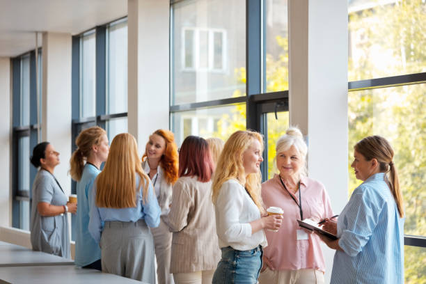 istock Female business entrepreneurs discussing with each other while standing in office during networking event 2119869474