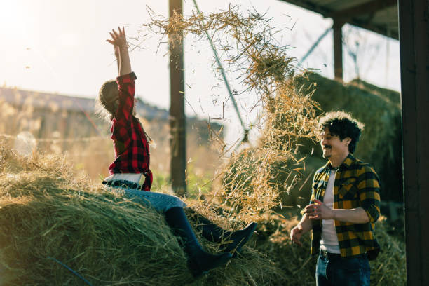 dad and his daughter spend time at their ranch and play in the straw