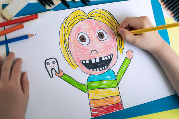istock Little child drawing a portrait of a child with missing teeth 2119875991