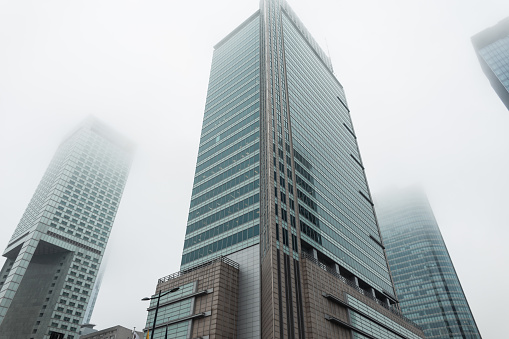 Beautiful modern city with tall business and office buildings on a foggy day in Warsaw