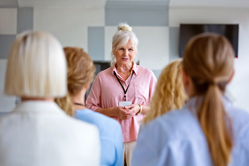 Mature businesswoman giving presentation during seminar at workplace