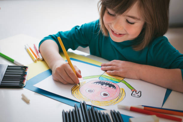 istock Cute boy draws a portrait of a child with missing teeth 2119880906