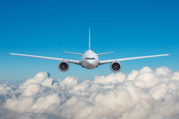 istock Beautiful panoramic background clouds cumulus with flying plane in blue sky. Passenger airplane straight view in sky. Travel concept. 2119881947