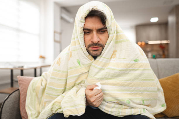 istock Sick man covered with blanket at home 2119884437