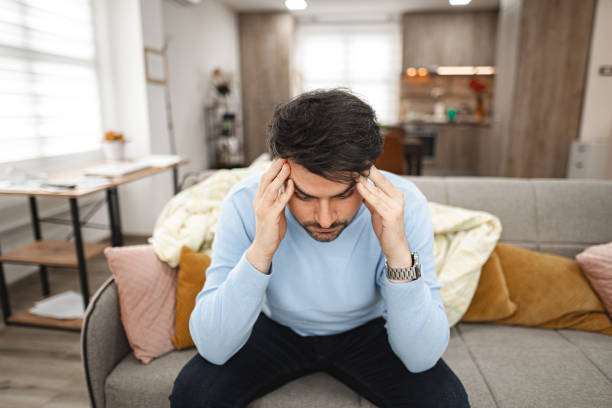 istock Man experiencing painful headache at home 2119884713