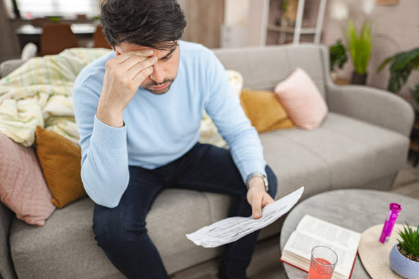 istock Worried man looking at documents at home 2119884746
