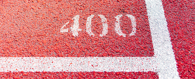 Bright red running track with white line and number 400.Close-up.Web banner.