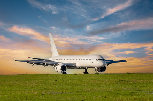 Passengers airplane landing to airport runway in beautiful sunset light, mileage and braking speed reduction.