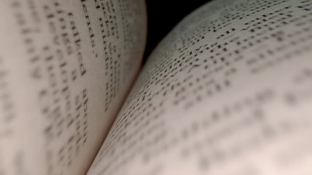 The camera moves between the pages of an open book. Closeup. Macro