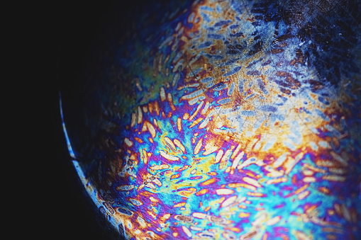Close up of texture and colors of the bottom of a burnt pot.
