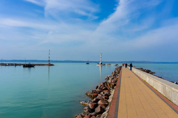 pier in Siofok Hungary with a gold angel statue and walking path .