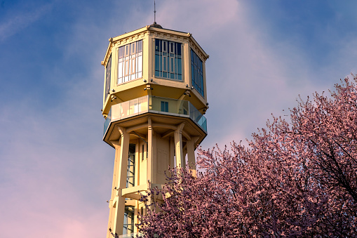 Siofok water lookout tower with blooming tree in Hungary spring travel .