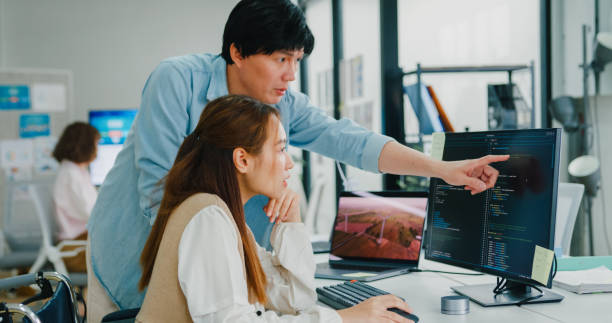 istock Asian manager instructs a new hire, demonstrating the collaborative spirit in a tech-focused office that values accessibility and sustainability. ESG sustainable business office. 2119958438