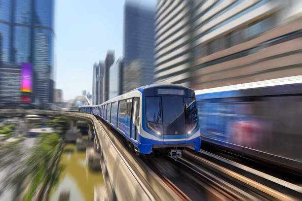 istock Modern high speed train over ground on a bridge on stilts among skyscrapers metro with turn speed motion blur. 2119965218
